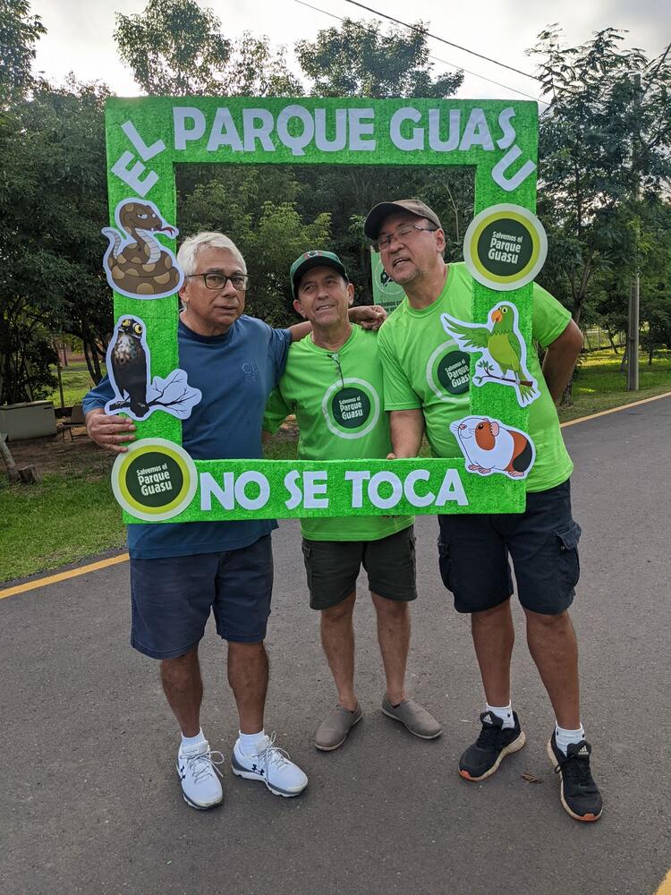 Tres personas posan con un marco que dice «El Parque Guasu no se toca»